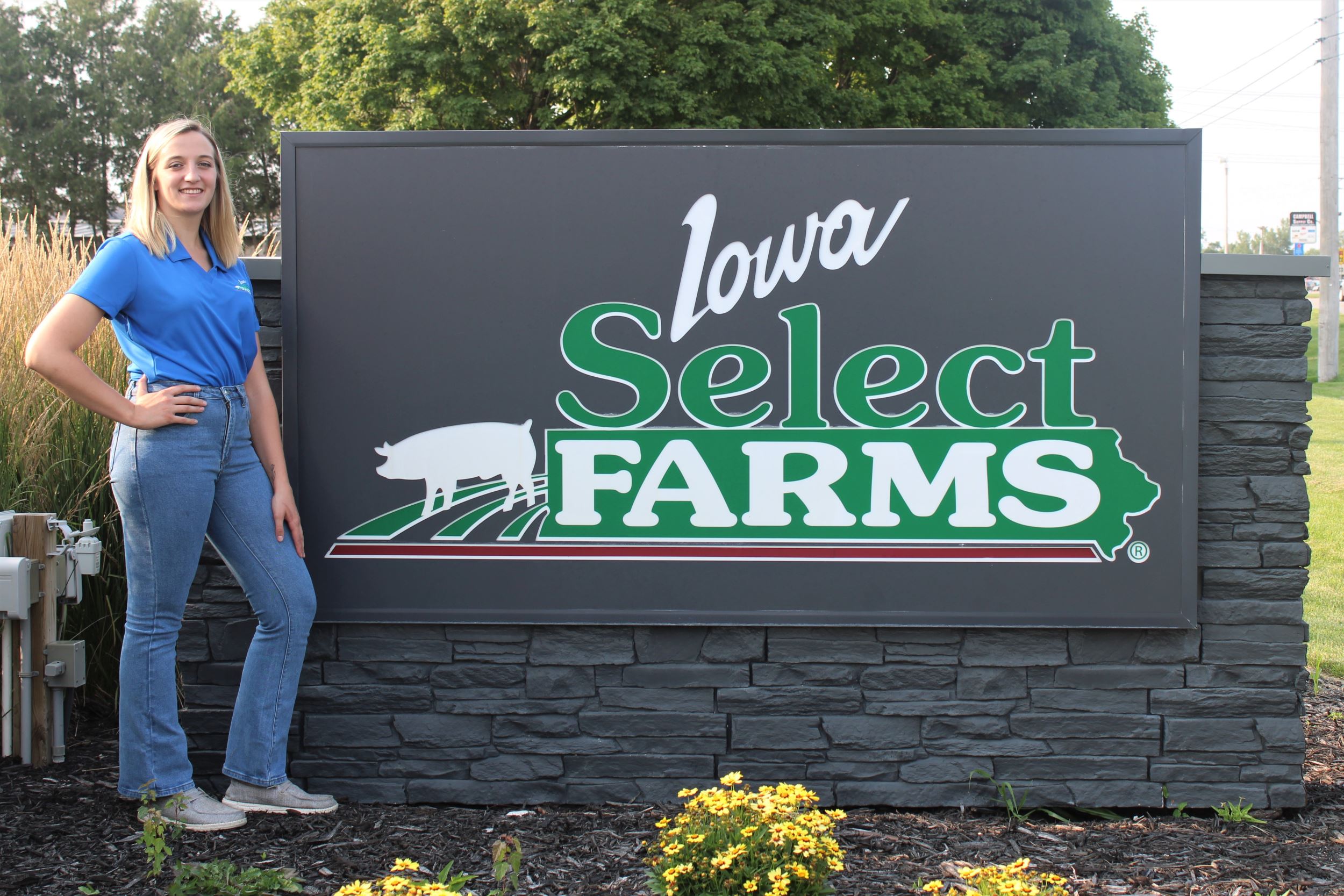 Addisyn poses by an Iowa Select sign.